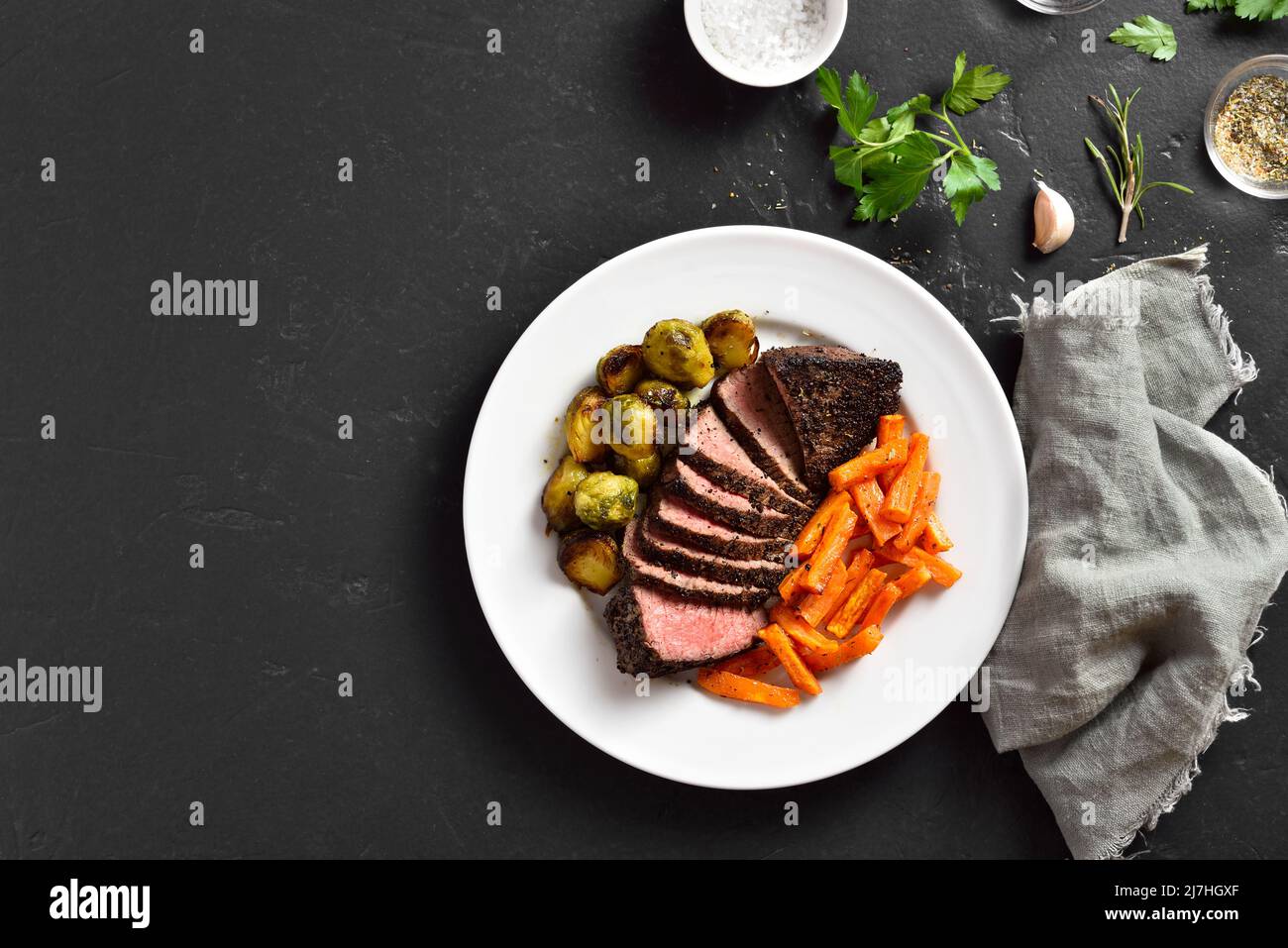 Grilled beef steak with brussels sprouts and sweet potatoes on plate