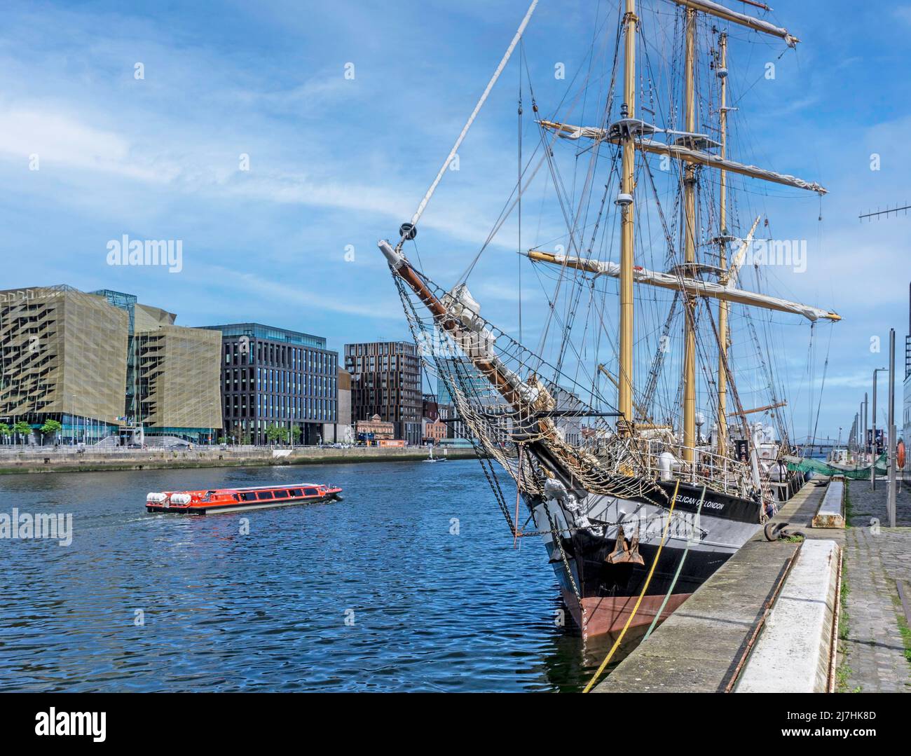 The tall ship Pelican of London pictured here against the modern office buildings of Dublin Docklands as a sightseeing tour passes by. Stock Photo