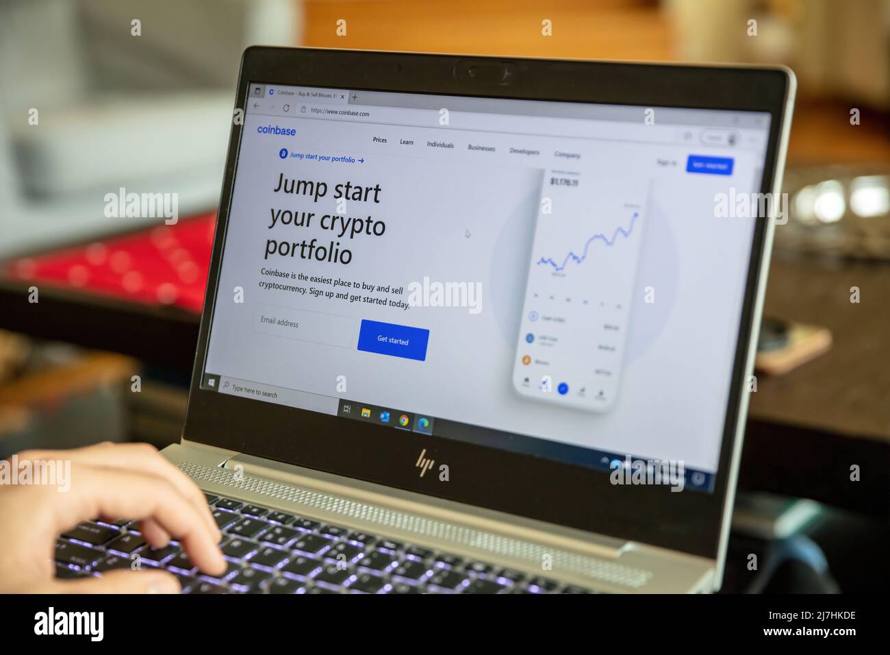 Greece, Athens, January 23 2022. COINBASE CRYPTO Exchange App. E commerce, cryptocurrency secure buy, sell on laptop computer screen. Male hand on key Stock Photo