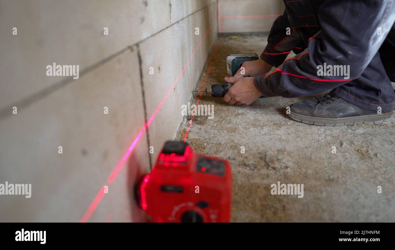 Wall repair process. A worker is drilling a wall. Installation of metal