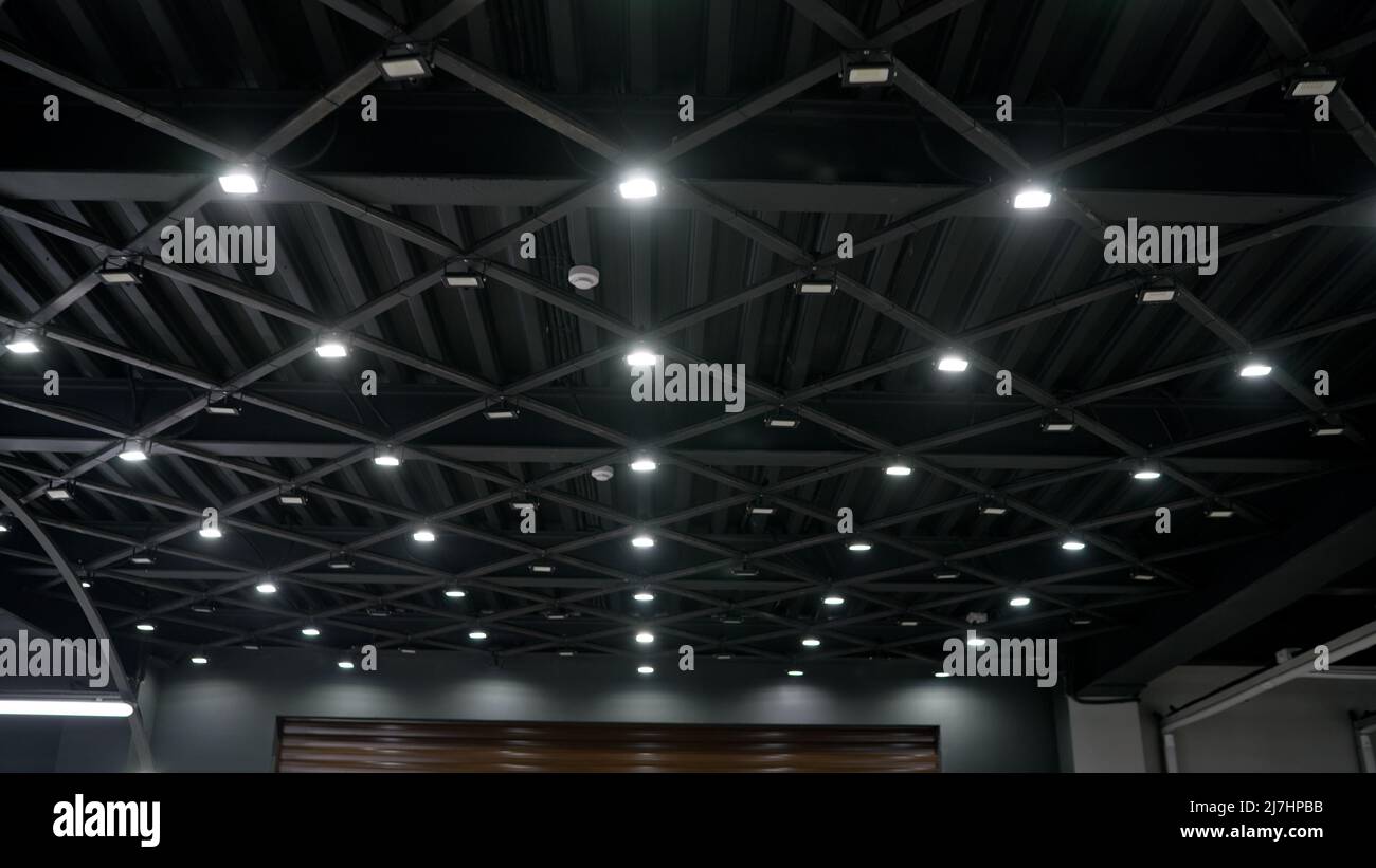 Stylish black ceiling with lamps in a car showroom. Modern ceiling solution in black style. Ceiling in the showroom and car detailing. Stock Photo