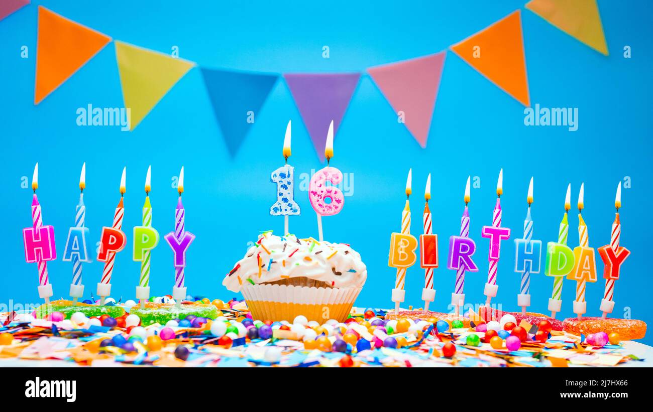 Happy birthday candle letters with a number or digit on a beautiful blue background. Copy space