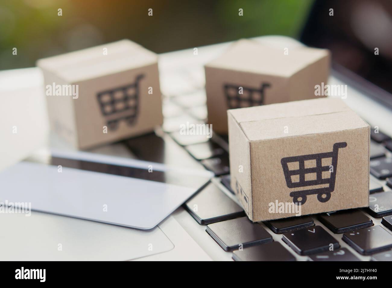 Shopping online. Credit card and cardboard box with a shopping cart logo on laptop keyboard