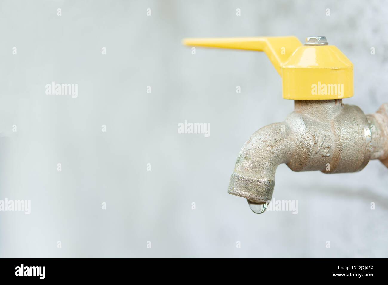 Faucet with a water drop. Old yellow faucet Stock Photo Alamy