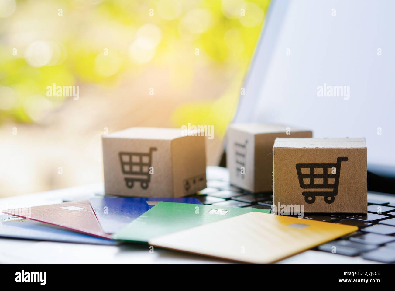 Shopping online. Credit card and cardboard box with a shopping cart logo on laptop keyboard