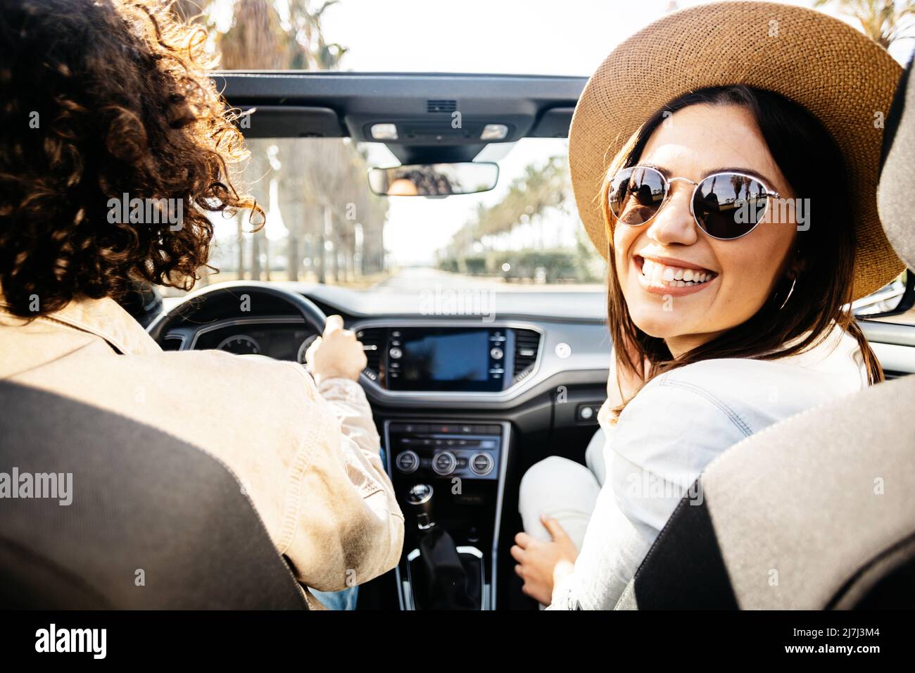 Couple enjoying a road trip together on a cabriolet. Stock Photo