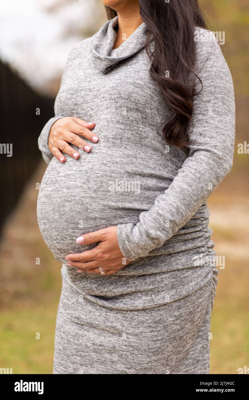 Happy Asian pregnant woman holding her stomach Stock Photo - Alamy