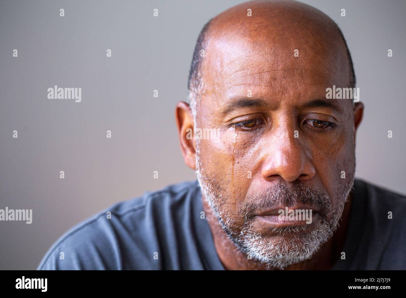 Portrait of a mature man looking sad with tears in his eyes. Stock Photo
