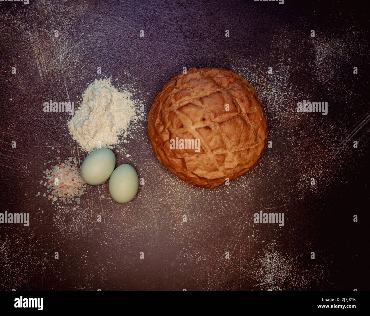Round sourdough bread with blue eggs, pink salt, and flour Stock Photo