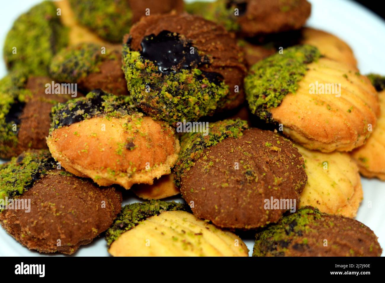 Traditional Arabic cookies for celebration of Islamic holidays of El-Fitr feast, petit four bakery (mignardises) stuffed with jam and nuts and covered Stock Photo