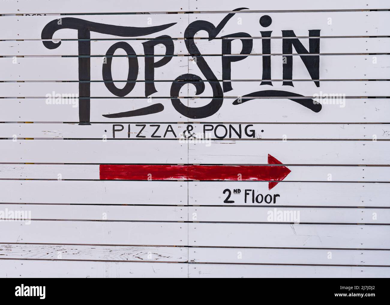 Temecula, CA, USA - April 11, 2022: Old Town neighborhood. Closeup of Top Spin logo from pizza restaurant is black on white with red directional arrow Stock Photo