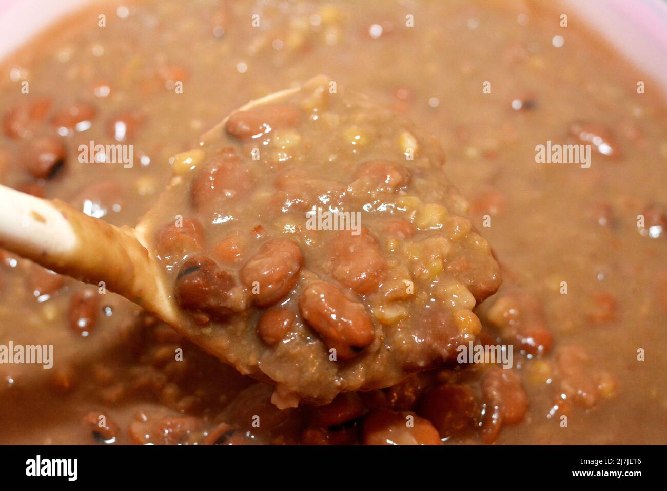 A ladle full of Egyptian fava beans which is the main dish and sandwich