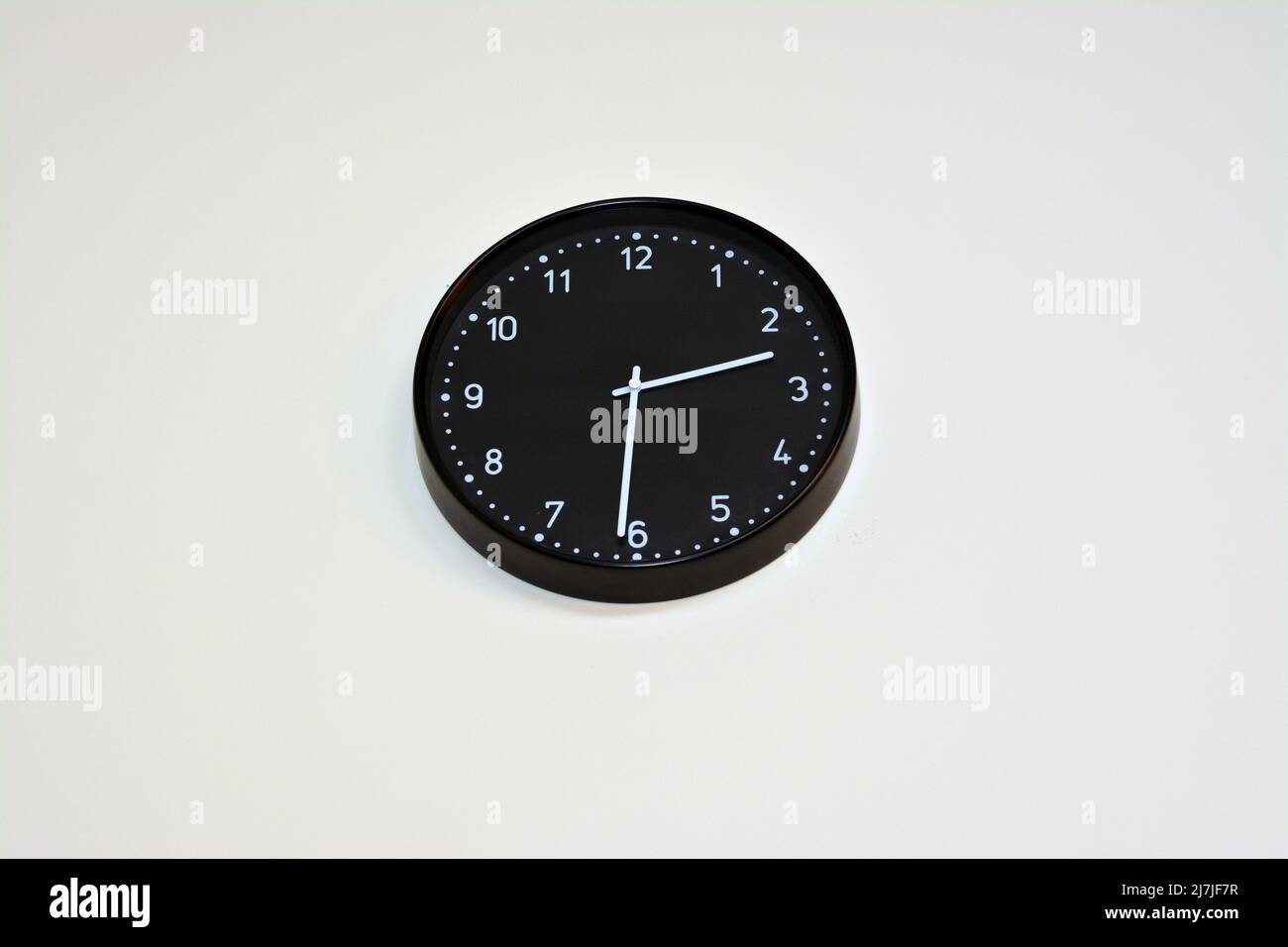 A black big clock hanging at the wall, time concept background