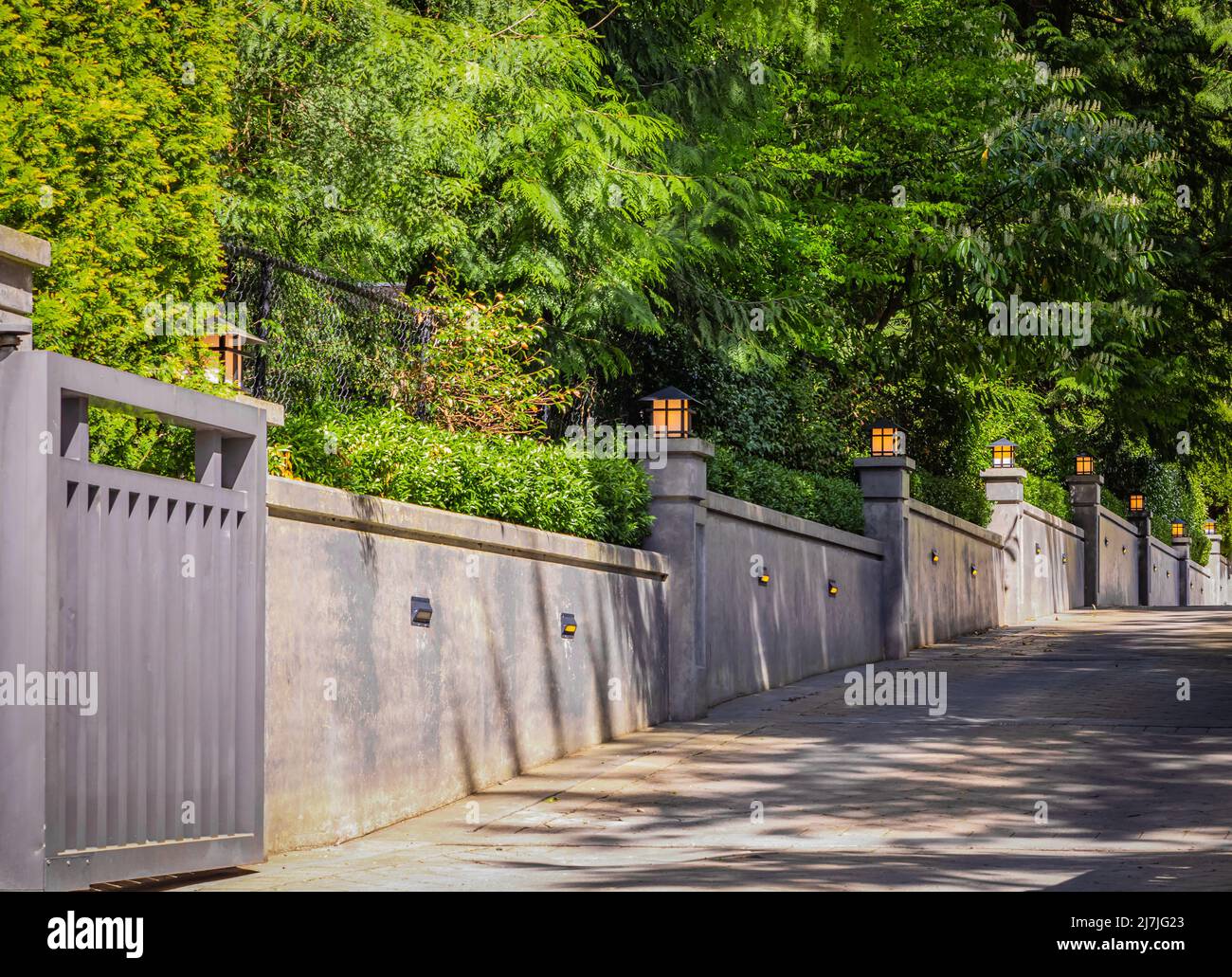 Exterior concrete fence wall with wall lights. Modern concrete
