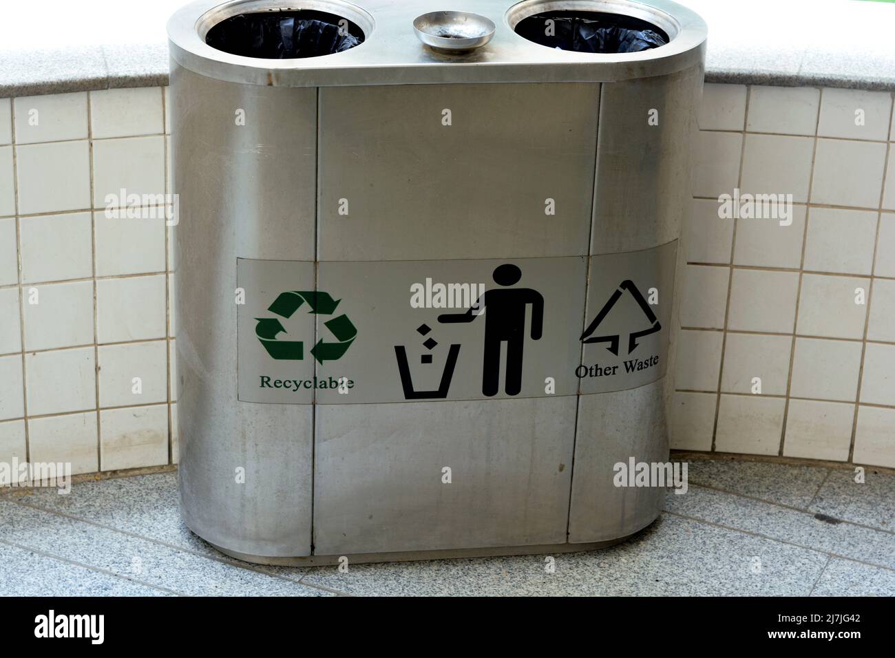 Recyclable and other wastes in a stainless steel metal trash bin for different garbage, Separation and sorting of rubbish, Container for sorting diffe Stock Photo