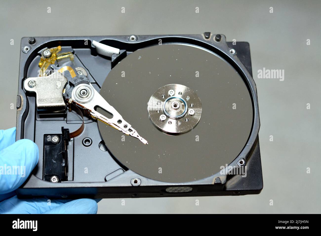 Disassembled computer hard disk drive storage memory with platters, spindle, actuator and read, write head, repair broken computer, data, hardware, an Stock Photo