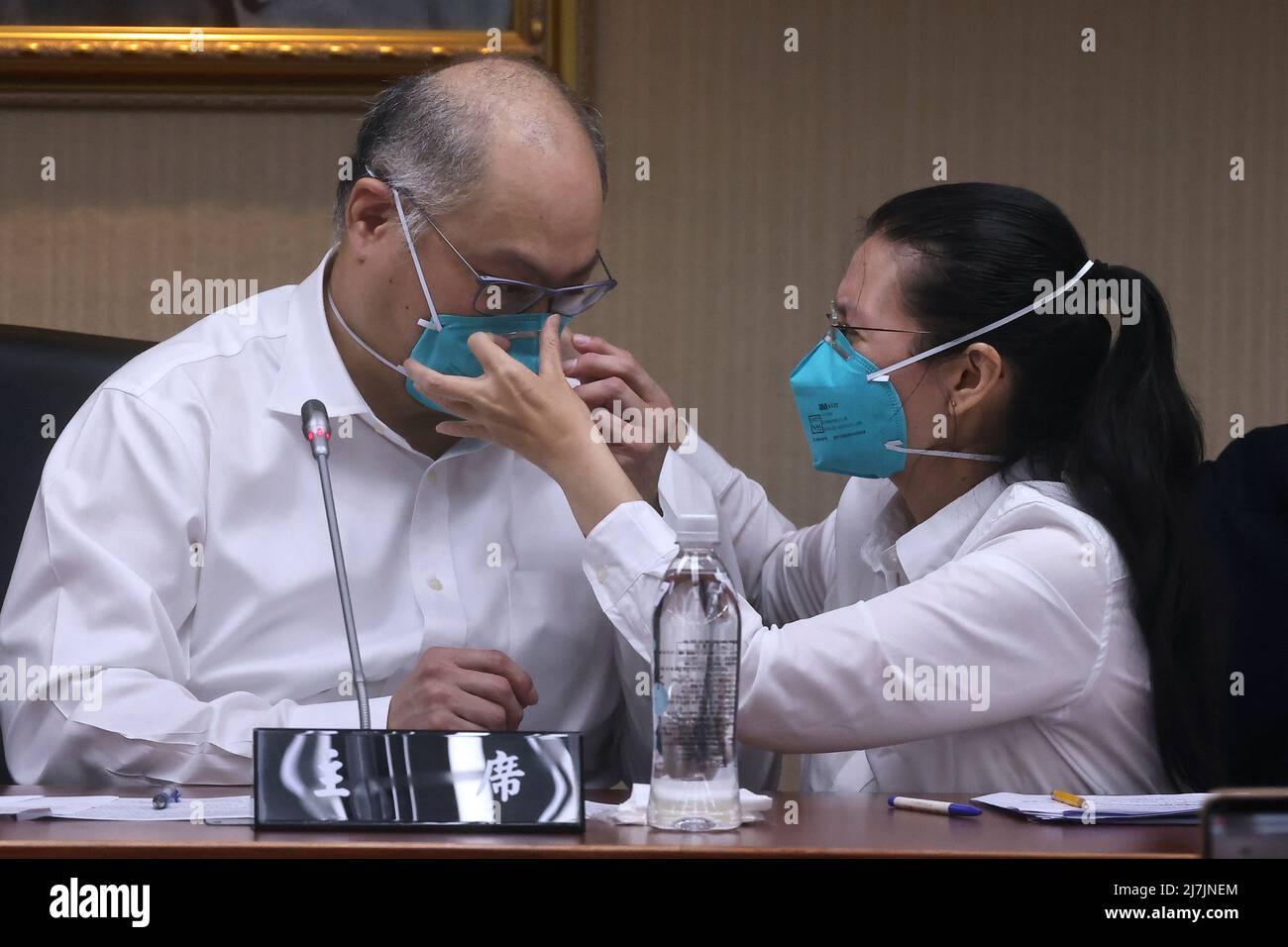 Taiwanese activist Li Ming-che's wife Li Ching-yu helps him adjust his face mask at his first news conference after being released from jail in China serving five years on a sedition charge in Taipei, Taiwan, May 10, 2022. REUTERS/Ann Wang Stock Photo
