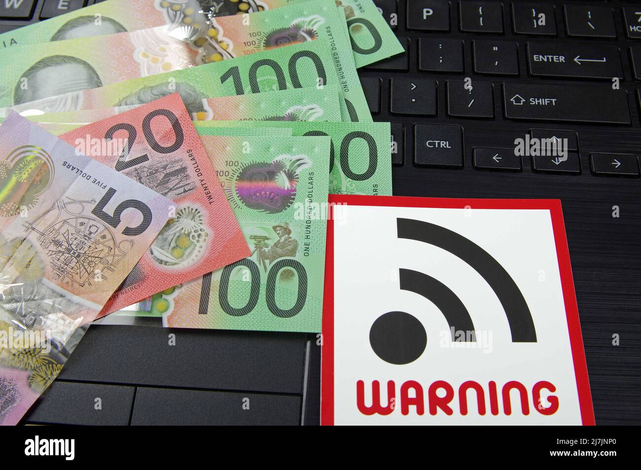 computer keyboard with WIFI warning sign and various bank notes Stock Photo