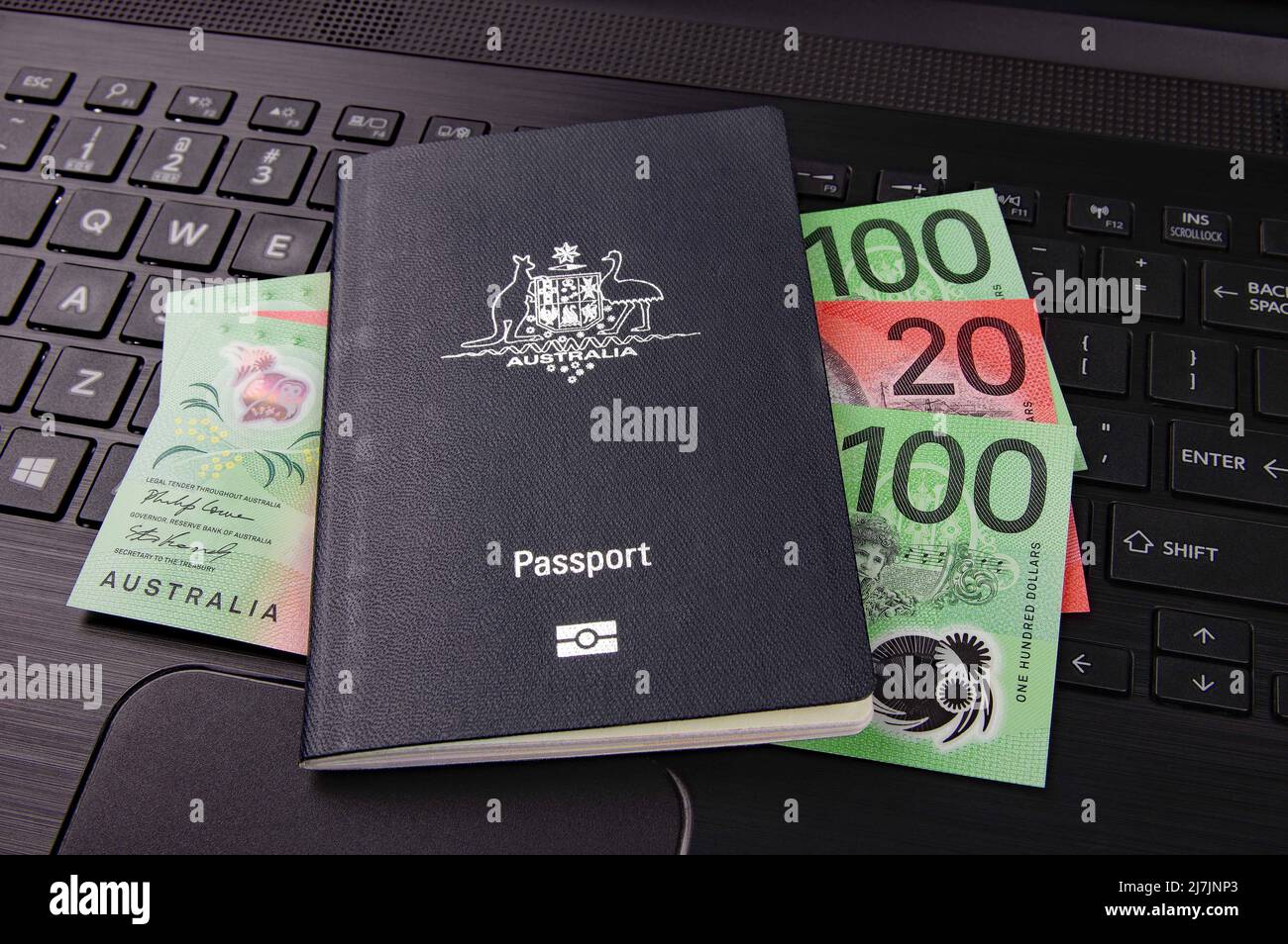 australian passport and bank notes on a black computer keyboard Stock Photo