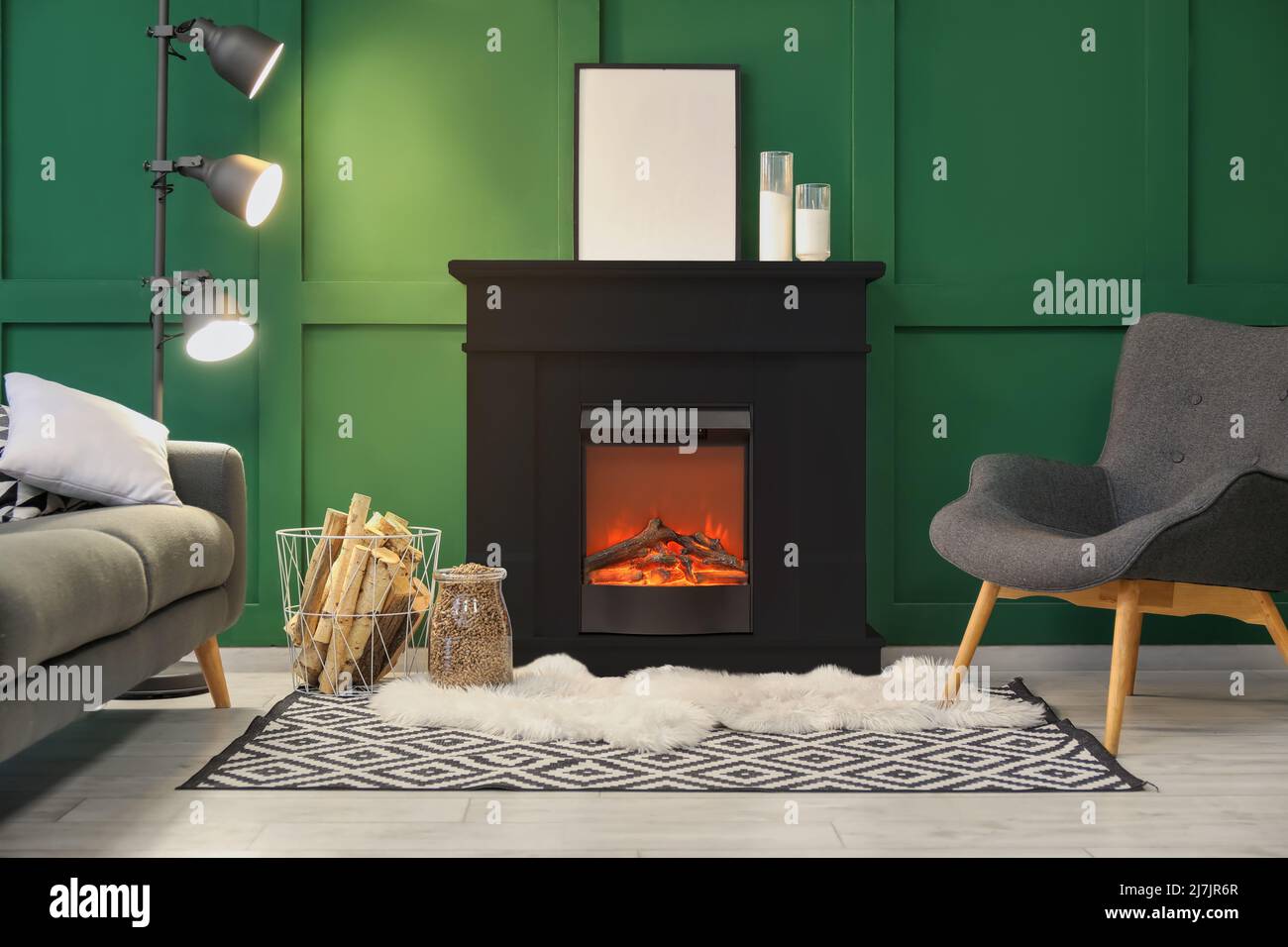Interior of modern living room with black fireplace, sofa, armchair and ...