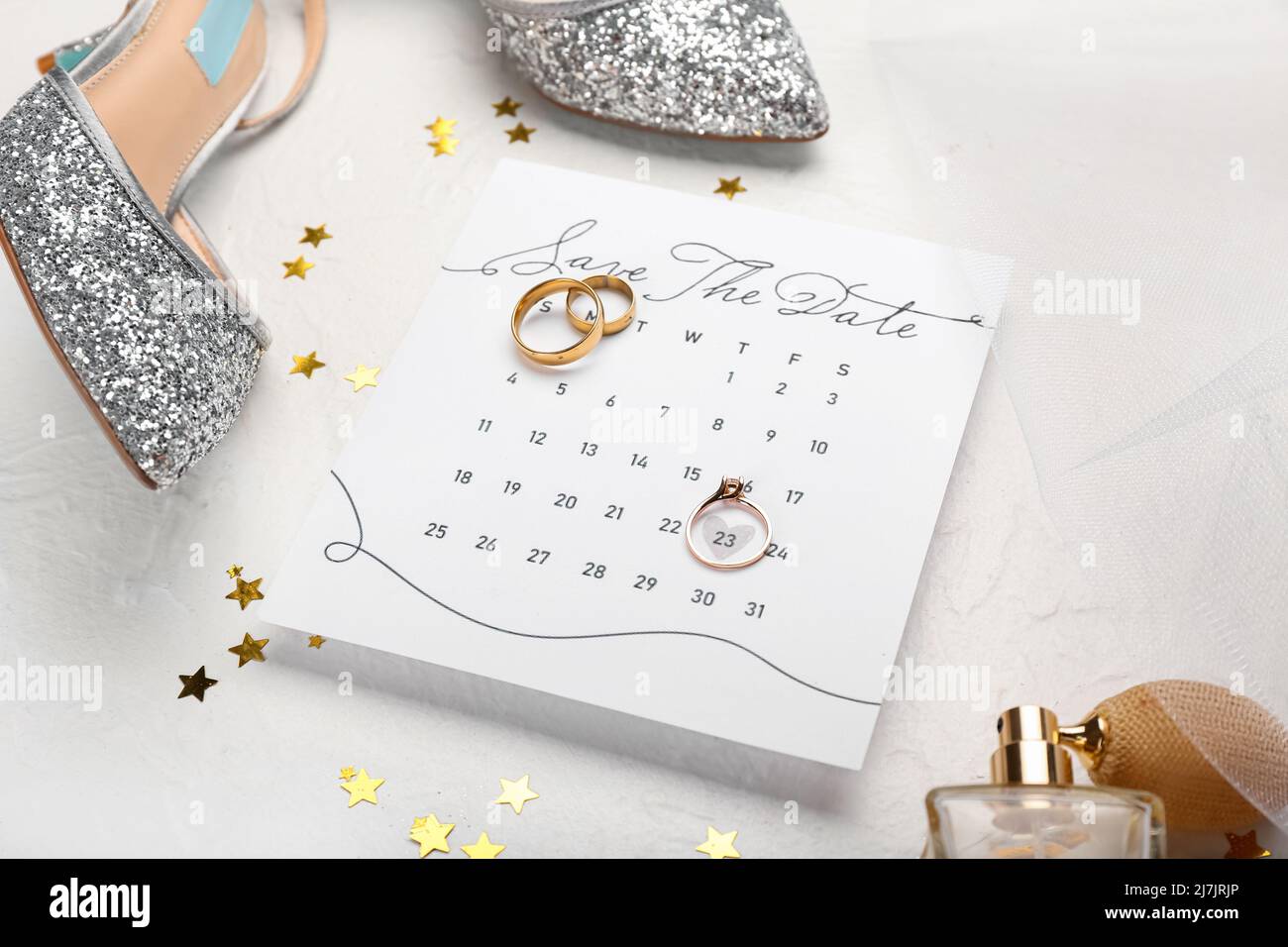 Calendar with marked date, wedding rings and stylish female accessories