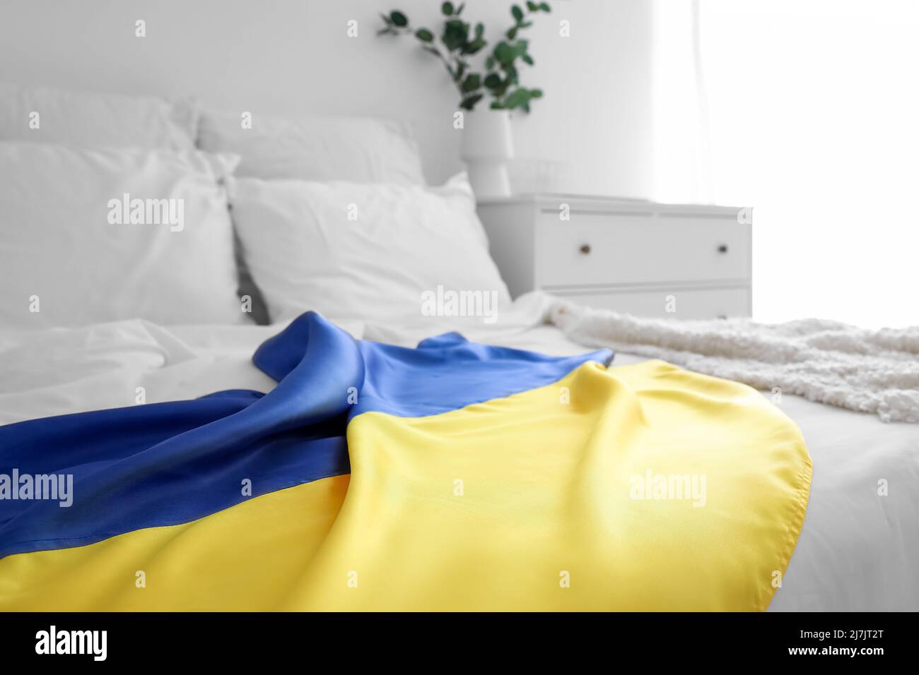 Flag of Ukraine on modern bed in light room, closeup Stock Photo - Alamy