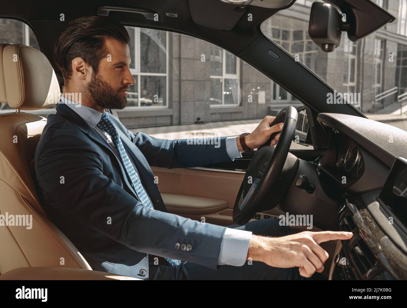 Seriously male entrepreneur in formal clothes traveling by automobile Stock Photo