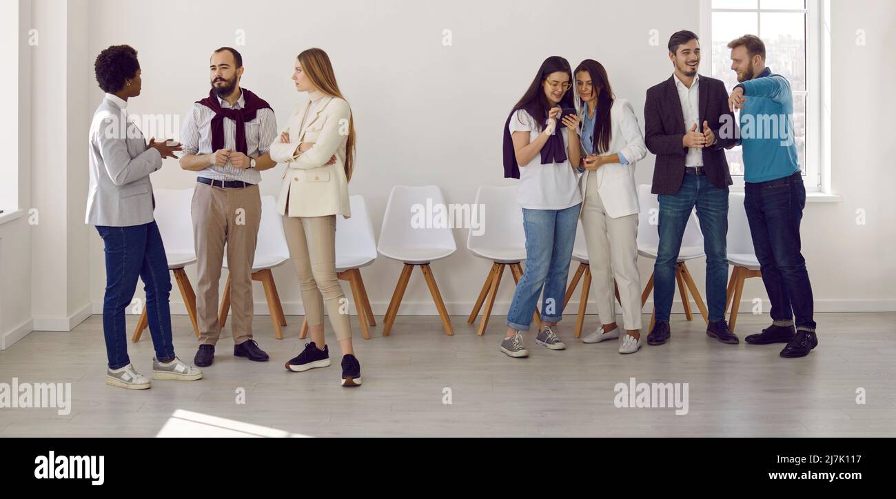 Groups of people communicate with each other while discussing presentation or business seminar. Stock Photo