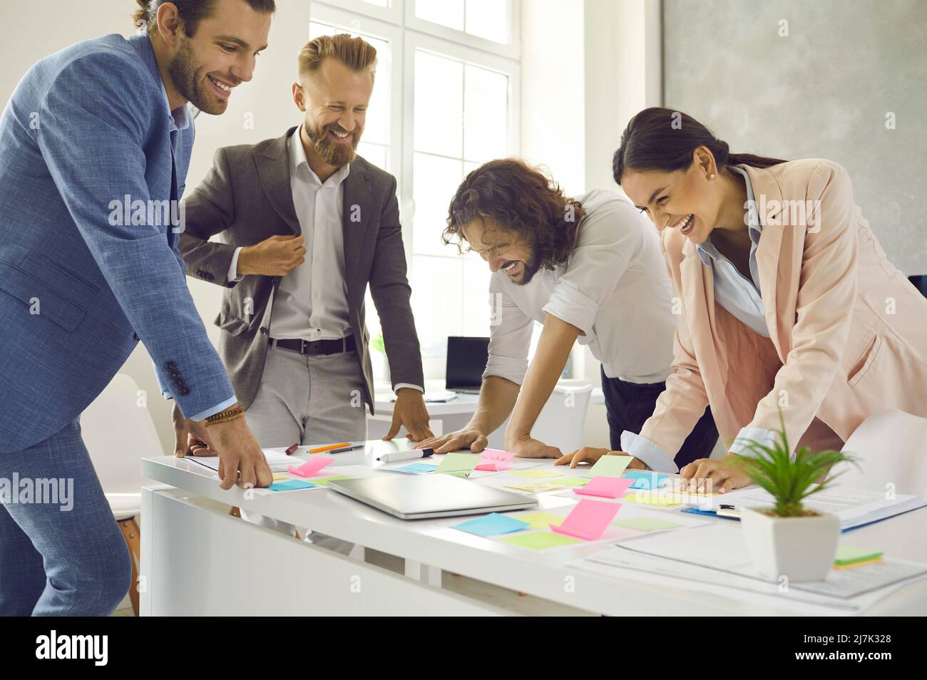 Smiling gen Z coworkers brainstorm discuss ideas in office Stock Photo
