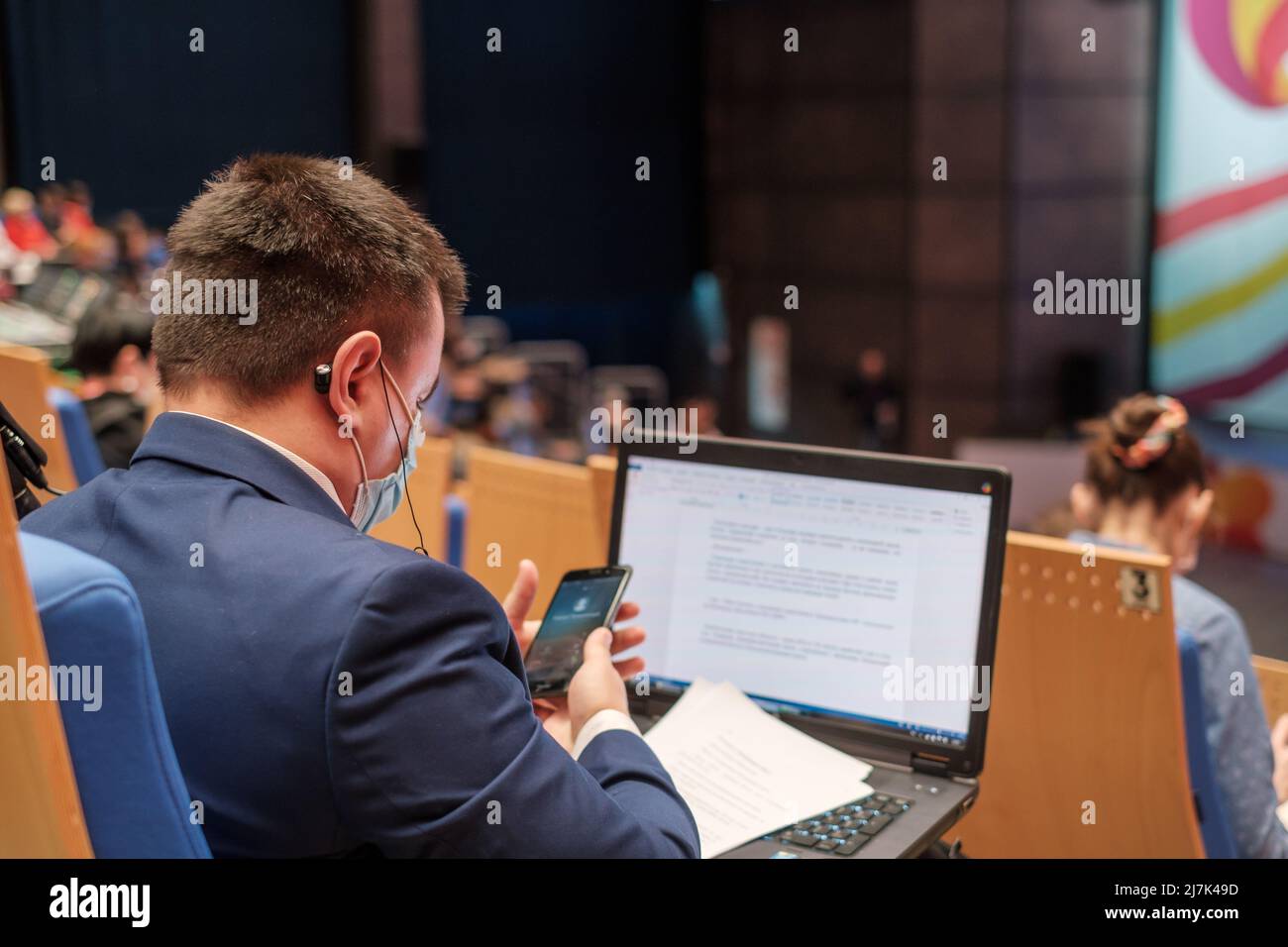 Businessman using laptop during seminar Stock Photo