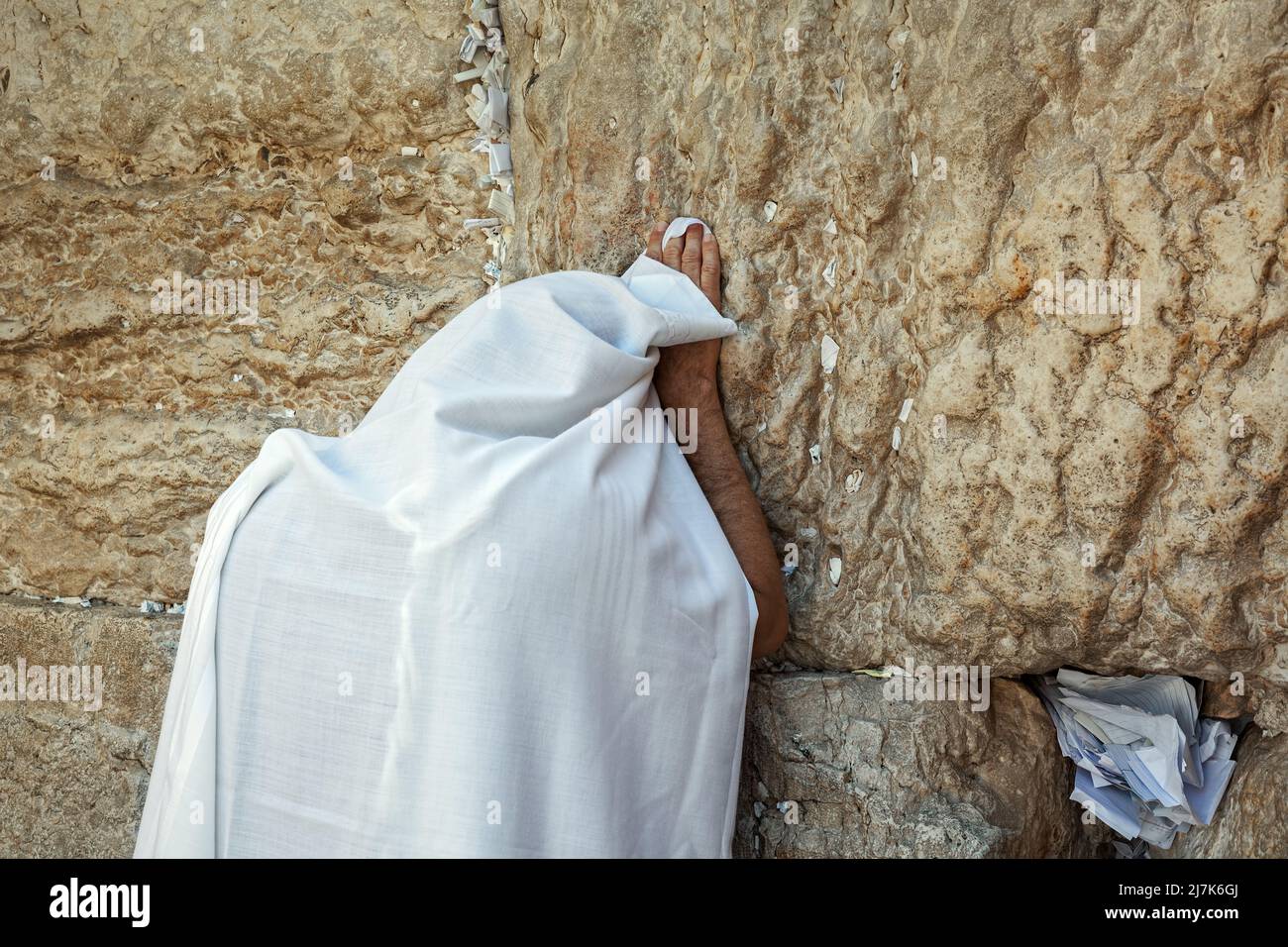 Man covered in white tallit praying at the Wailing Wall in Jerusalem, Israel. Stock Photo