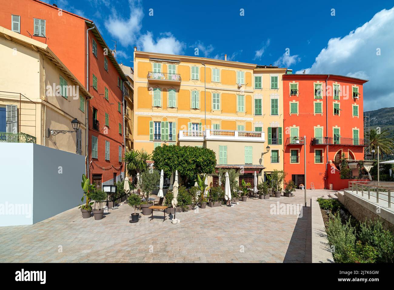 Small town square and colorful residential houses under blue sky in Menton, France. Stock Photo