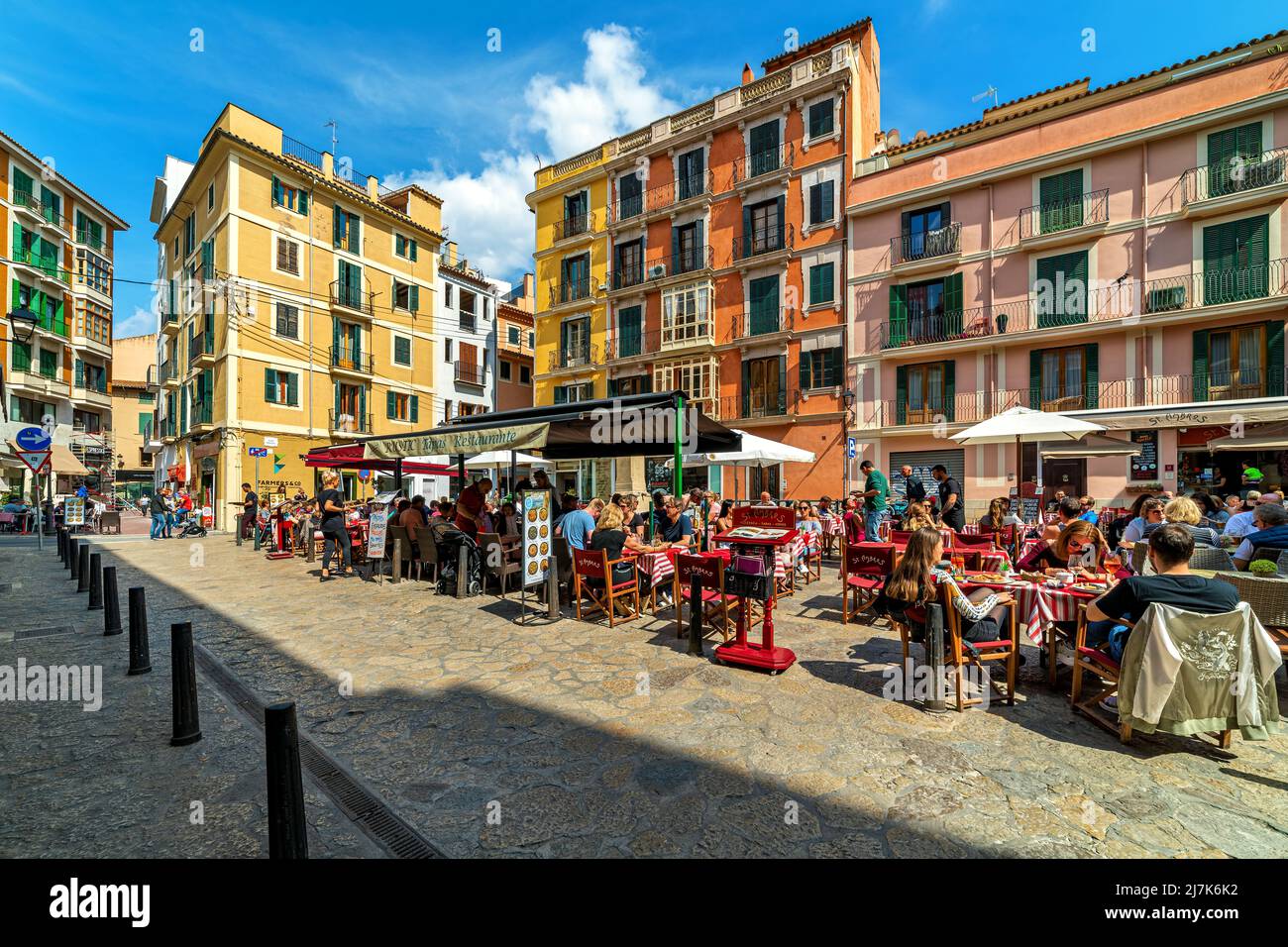 People sitting in outdoor restaurants on small town square in old historic part of Palma de Mallorca, Spain. Stock Photo