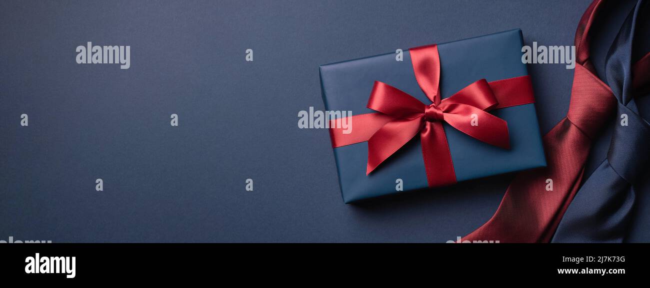 Banner with blue gift box and neckties on dark blue background. Father's day concept. Stock Photo