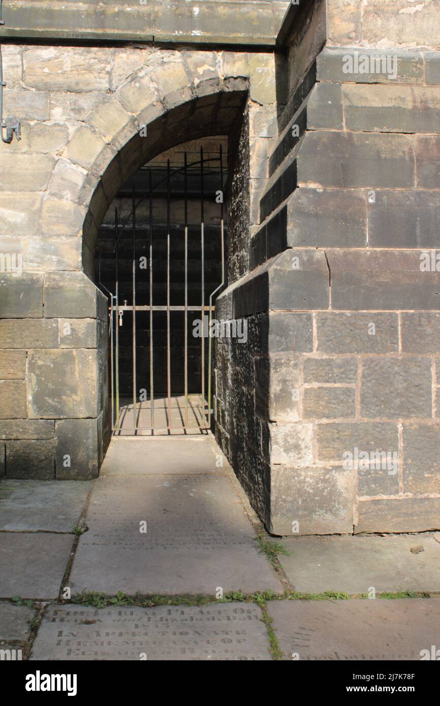 Half an arch brickwork from the 1300s with metal gate.  Medieval arch passageway with copy space Stock Photo