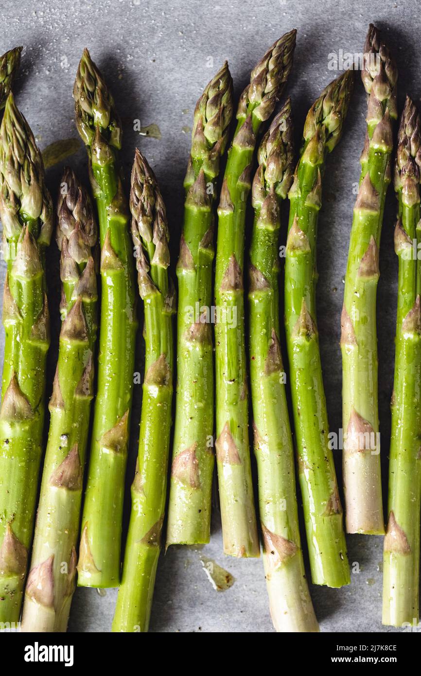 Fresh asparagus on baking paper, top view. Stock Photo