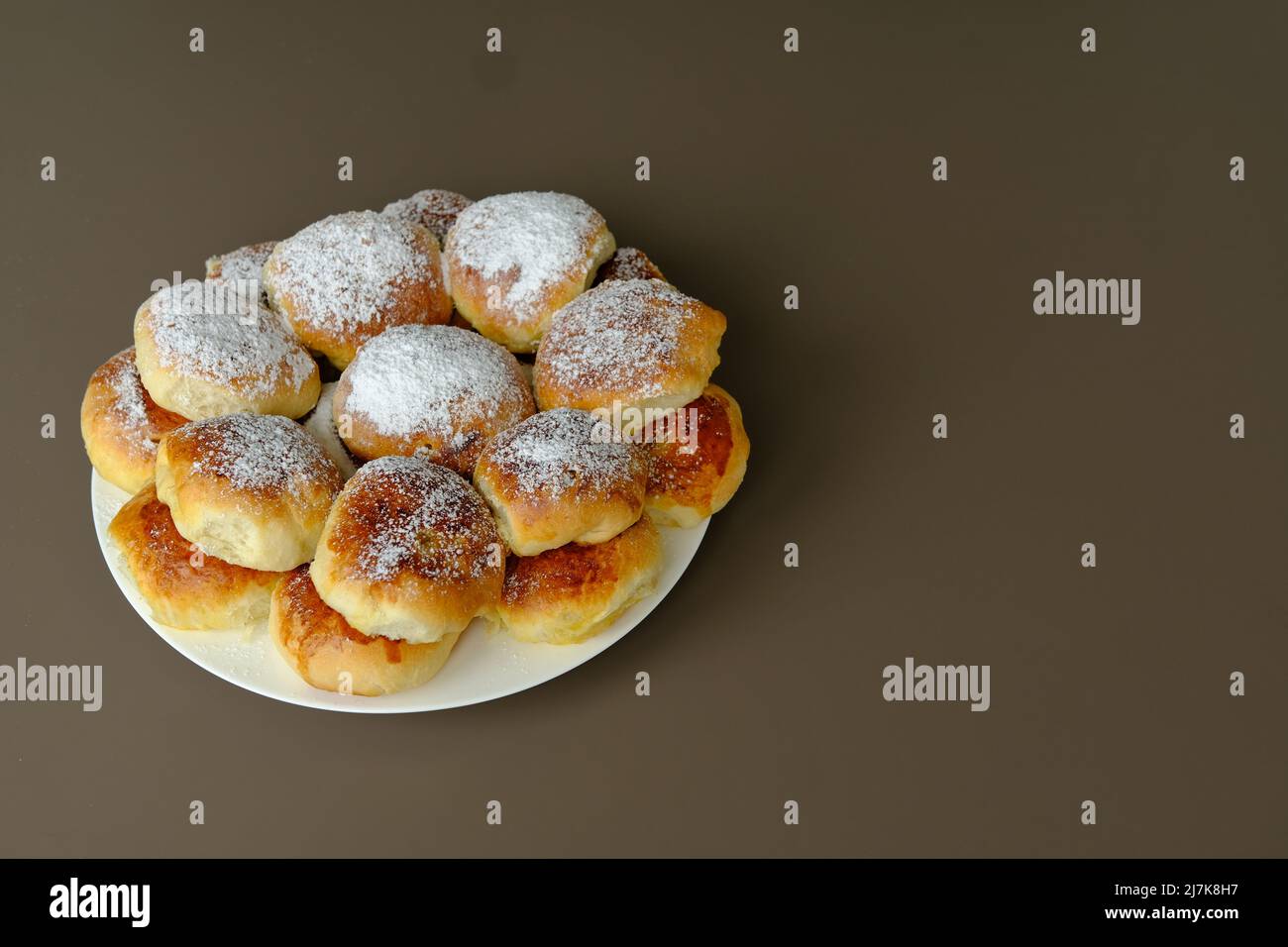 Homemade old fashioned apple dumplings or pies on a white plate and brown background. Baked according to Ukraine recipe. Stock Photo