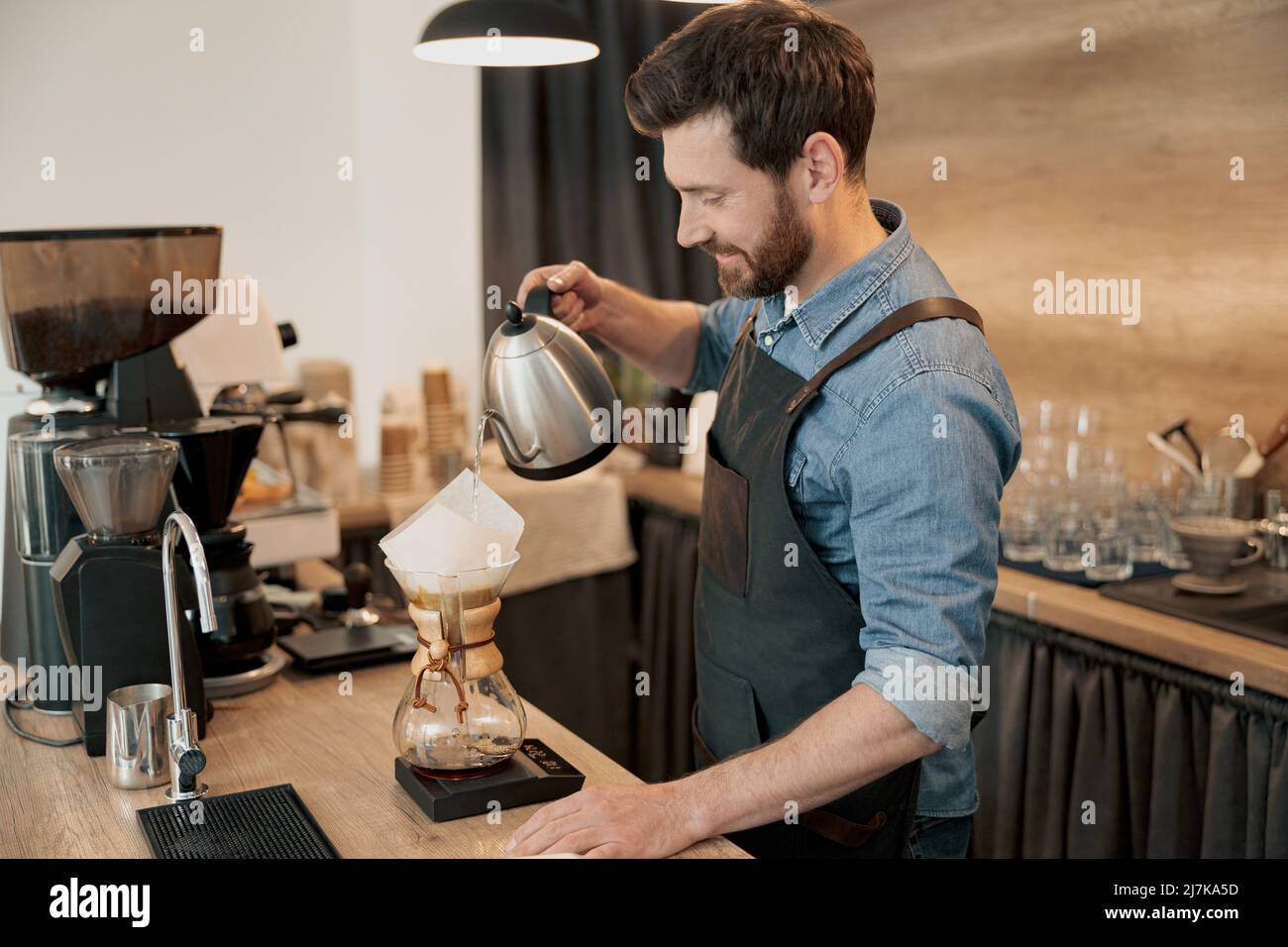 Barista pouring water to make coffee using manual drip brewer Stock Photo Alamy