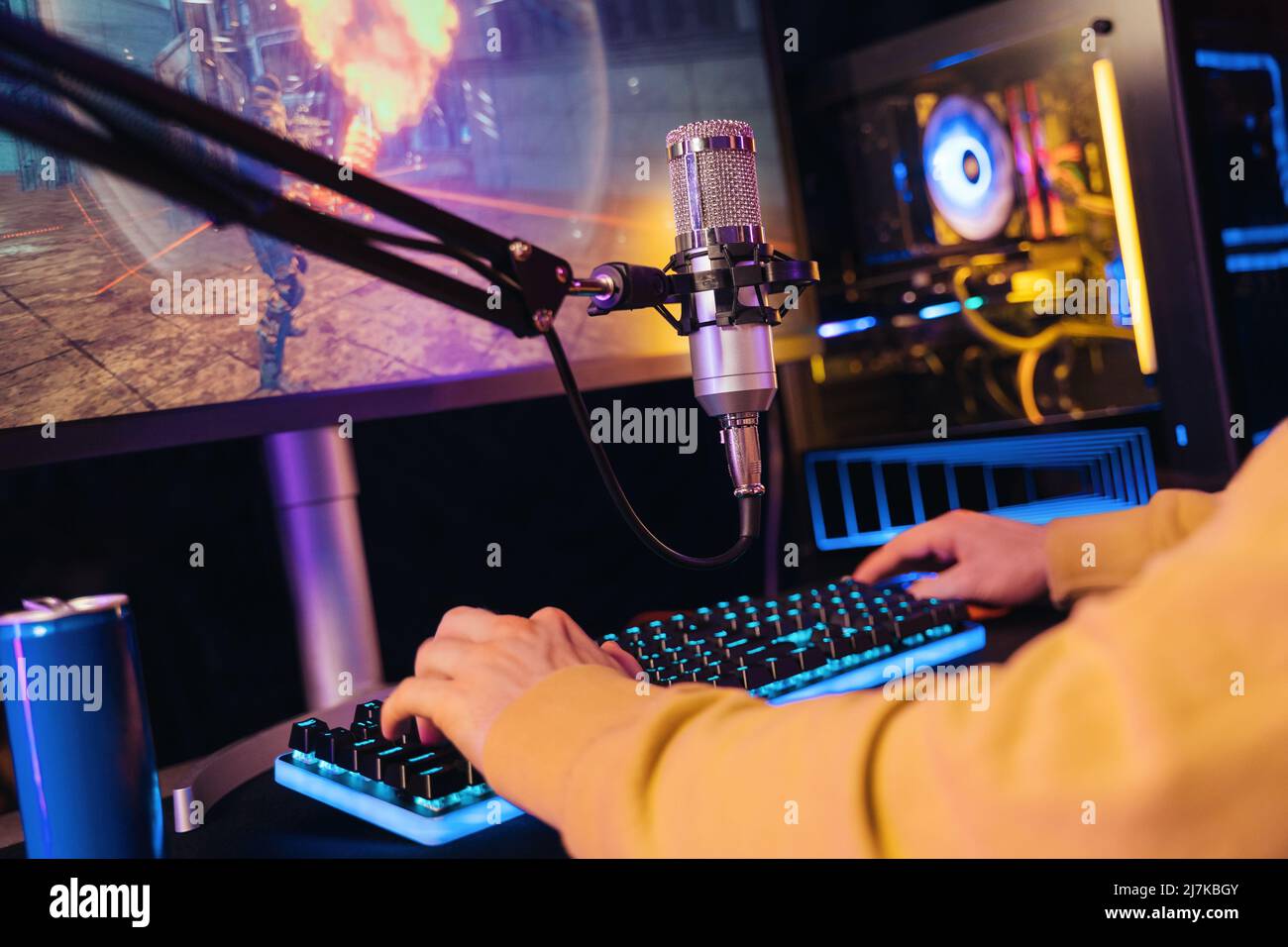 Close up of pro gamers hands laying on gaming keyboard while he streaming his online video game passing on powerful PC at home