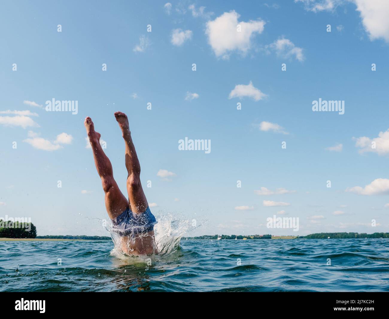 person diving into the water, view on human legs Stock Photo