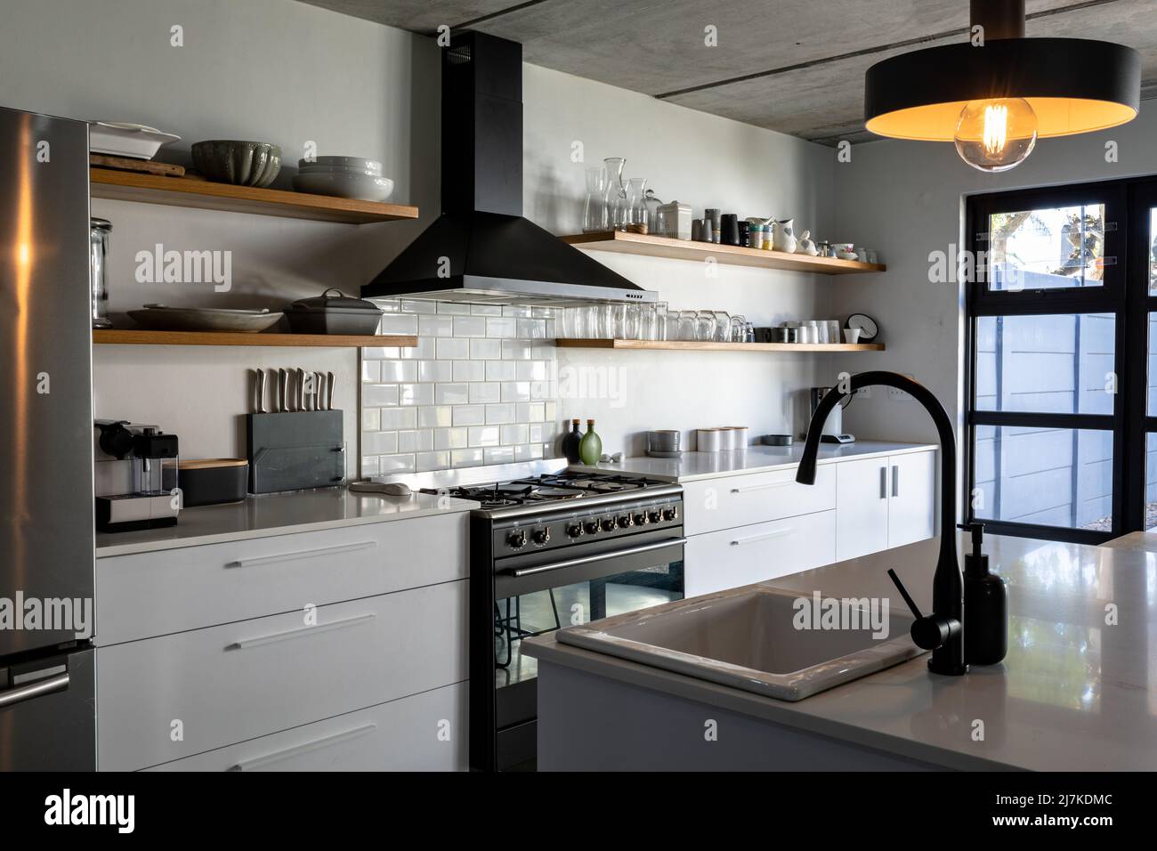 Interior of modern kitchen with illuminated pendant lights over sink at kitchen island Stock Photo