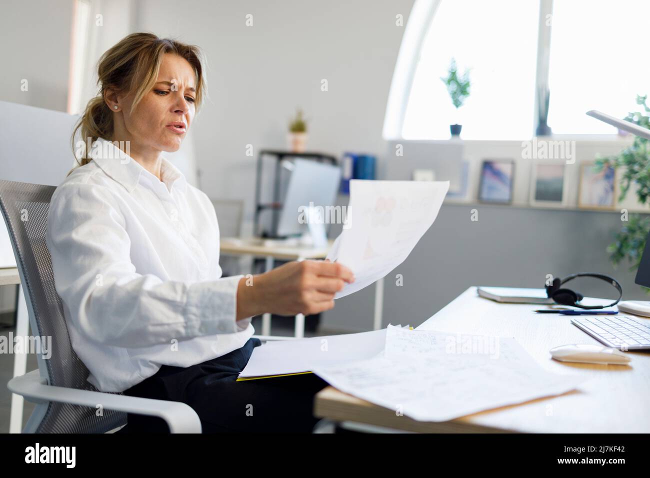 Business woman examines documents while sitting at the office workplace Stock Photo