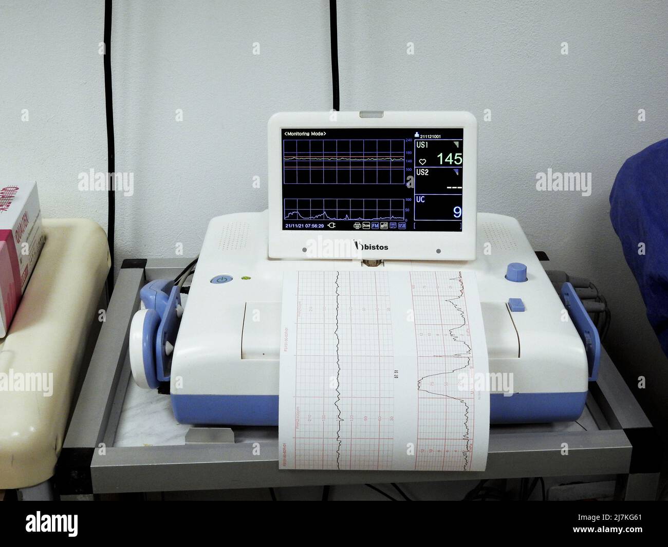 Cairo, Egypt, November 21 2021: Cardiotocography device placed on mother's abdomen recording the fetal heart rate obtained via ultrasound transducer, Stock Photo