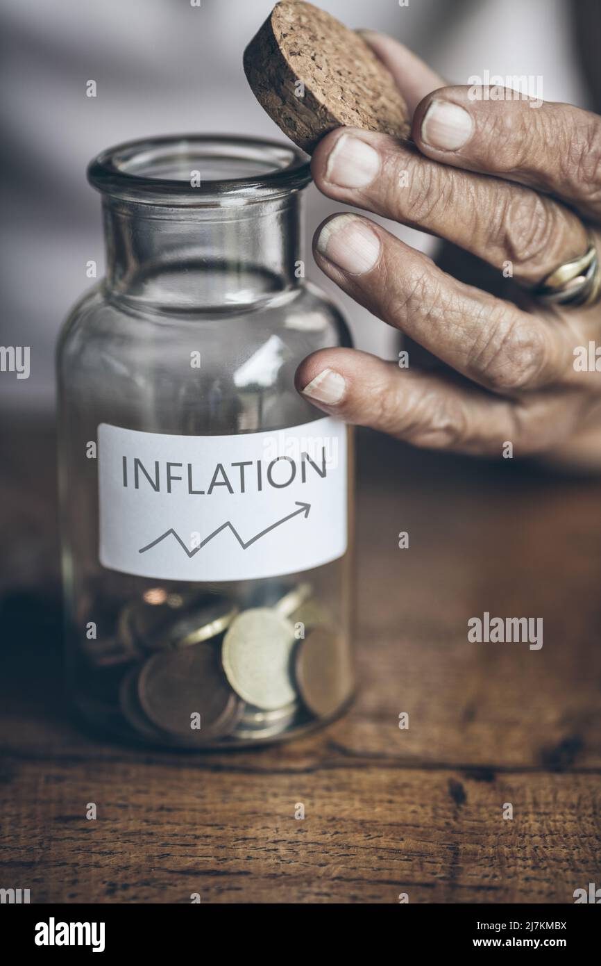 Elderly retired woman and her savings in a jar Stock Photo