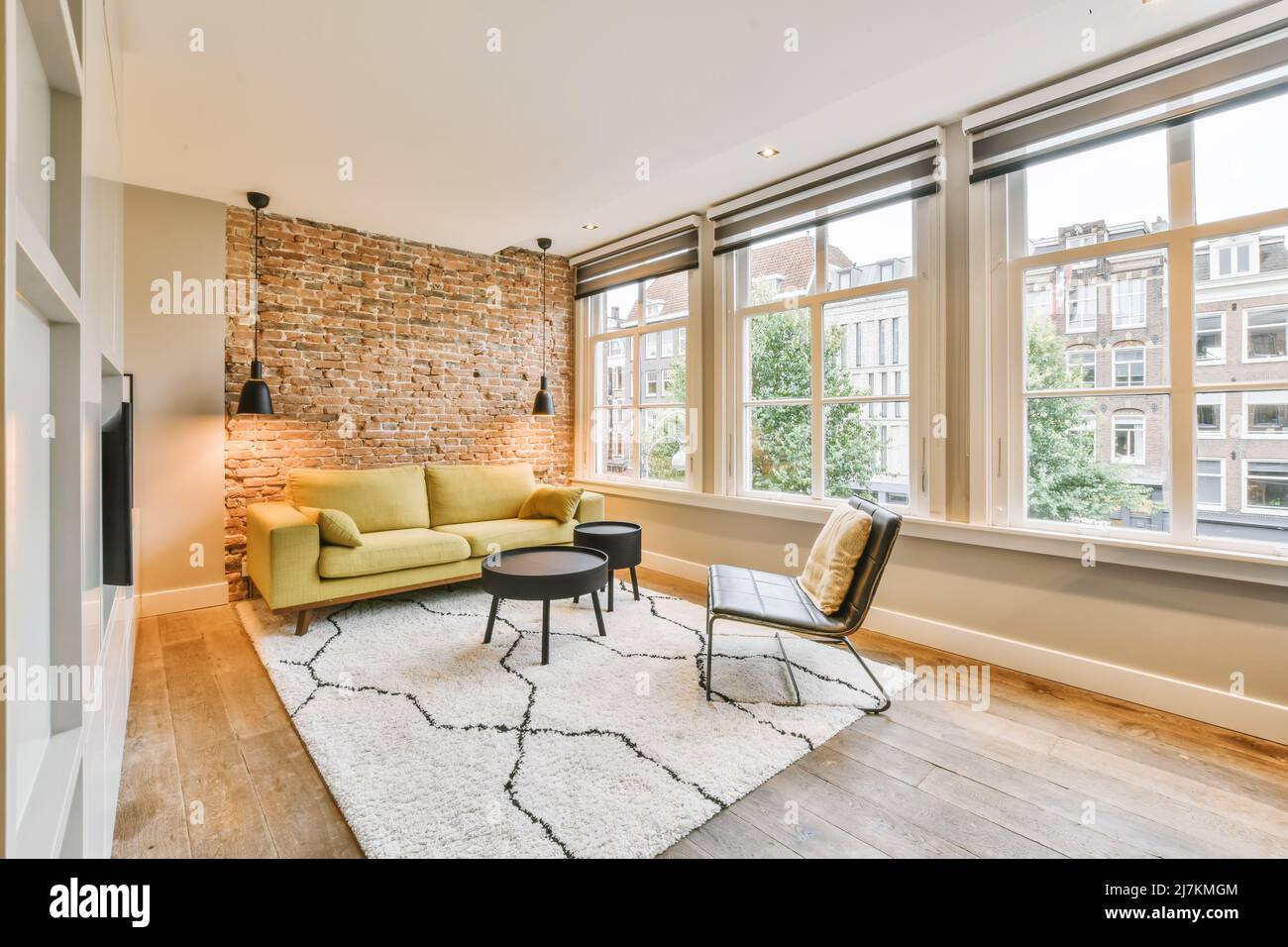 Comfortable sofa placed on rug near brick wall with lamps and black ...
