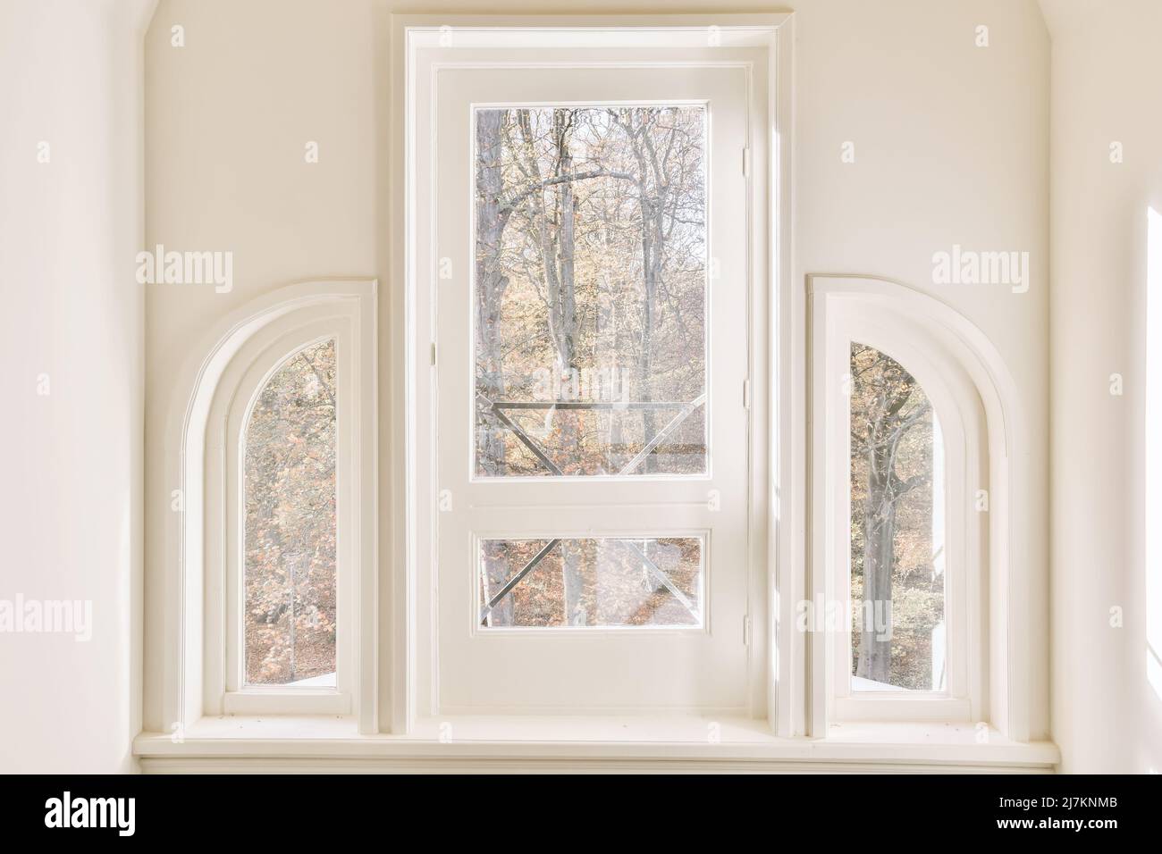 White windows in classic styled house overlooking autumn forest with ...