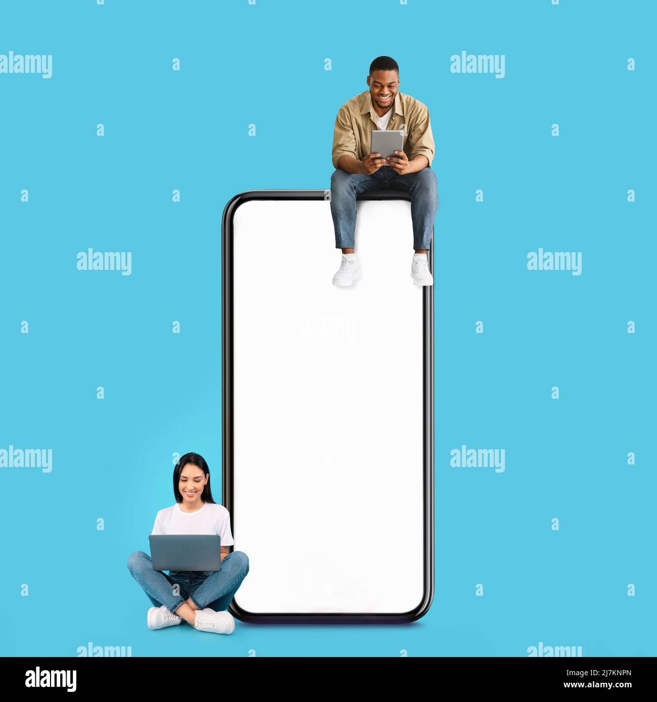 Couple sitting on white empty smartphone screen and using gadgets Stock Photo