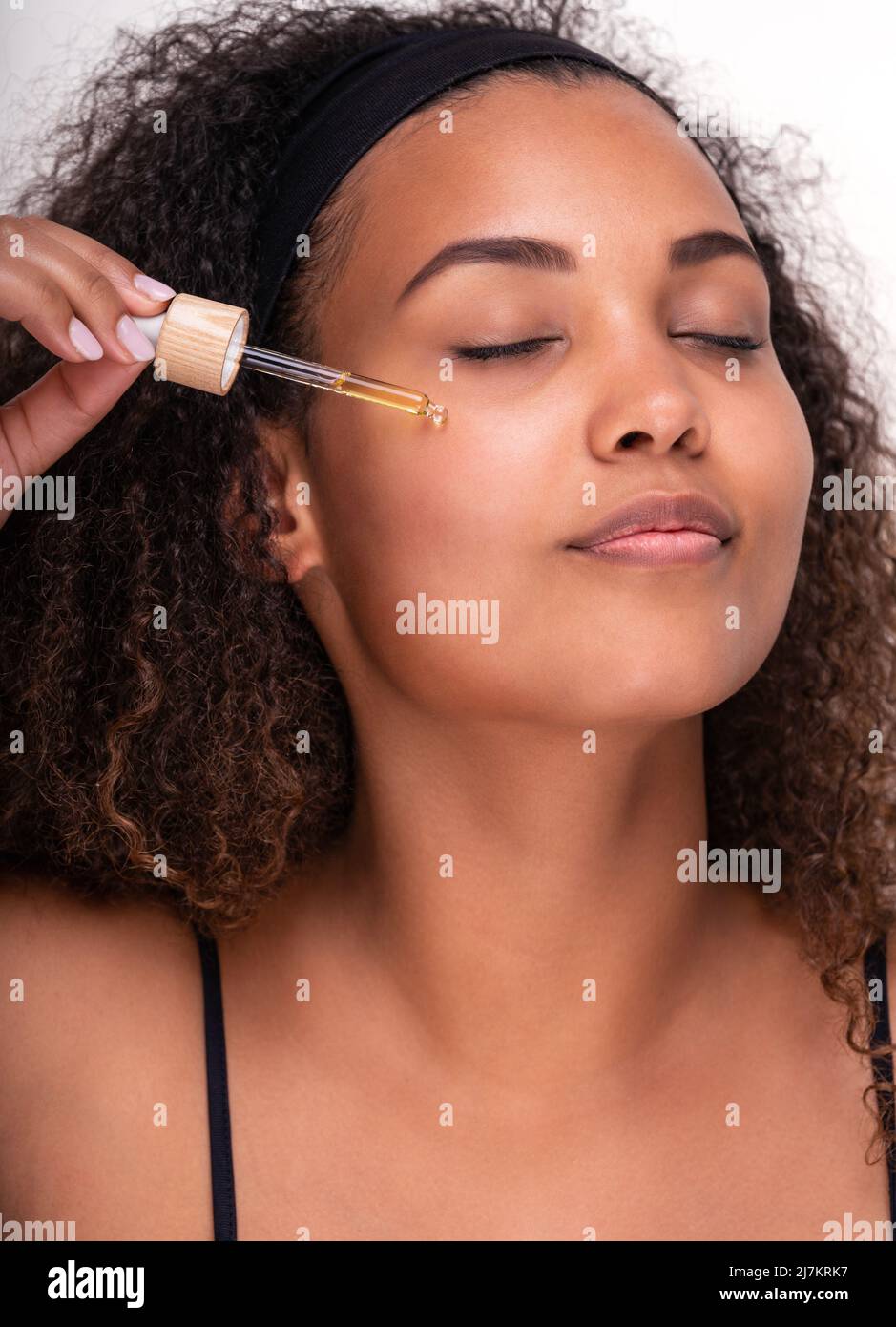 young Hispanic female model with perfect skin and long curly