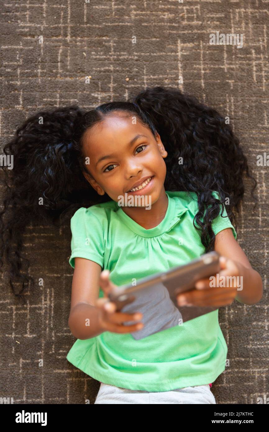 Overhead portrait of african american elementary girl with digital ...