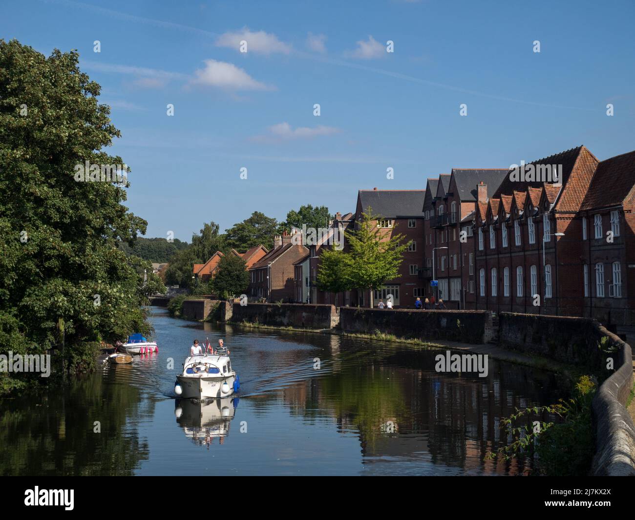 The River Wensum looking east from The Fye Bridge, with Motor Cruiser enjoying The Norfolk Broads, Norwich, Norfolk, England, UK Stock Photo